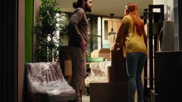 Couple unpacks decorations and belongings in their first home, with proud homeowners enjoying moving day, residential settlement, room decorating and the satisfaction of creating a home sweet home.