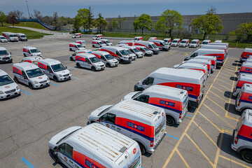 Obraz premium Canada Post delivery vans parked in a fleet parking lot. Canada. Canada Post is discontinuing door-to-door delivery and transitioning to community mailboxes: Toronto, Ontario, Canada - May 17, 2026