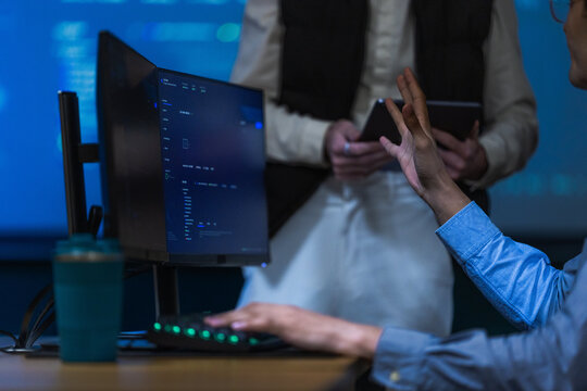 A smartly dressed male engineer in a navy blazer at his monitors sits back with a hand at his chin while weighing two options at a leading data driven organisation