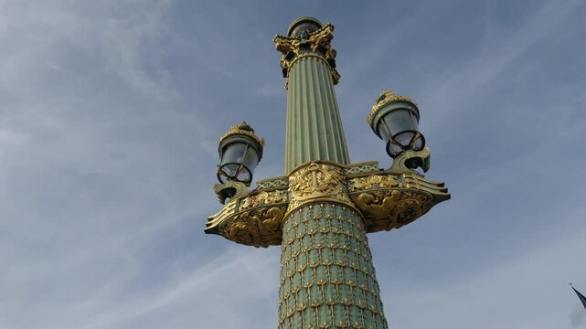 Ornate golden street lamp details against a blue sky, representing Parisian architecture and travel