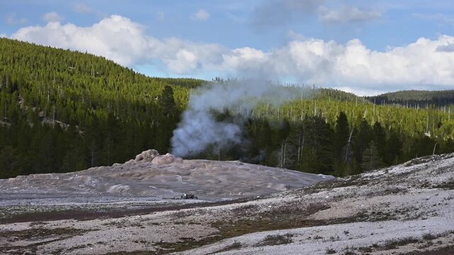 Early morning walk viewing geothermal features and hot springs in Old Faithful area of Upper Geyser Basin, summer vacation exploring Yellowstone National Park
