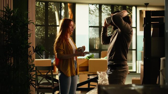 Man homeowner uses VR glasses to visualize furniture and decorations for a first home, designing a floor plan model and room arrangement for the layout of his new house during relocation.