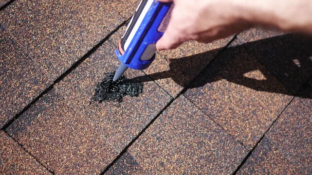 Man uses Tar to Repair Roof Shingles