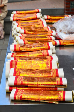  stacks of golden Joss papers arranged neatly on a table for religious ceremonies and offerings