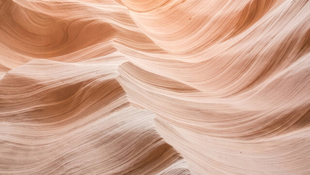 Smooth swirling layers of sandstone canyon walls illuminated by soft light