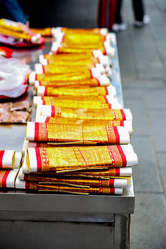  stacks of golden Joss papers arranged neatly on a table for religious ceremonies and offerings
