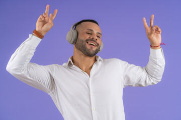Fototapeta premium Young adult man listening music celebrating happiness peace