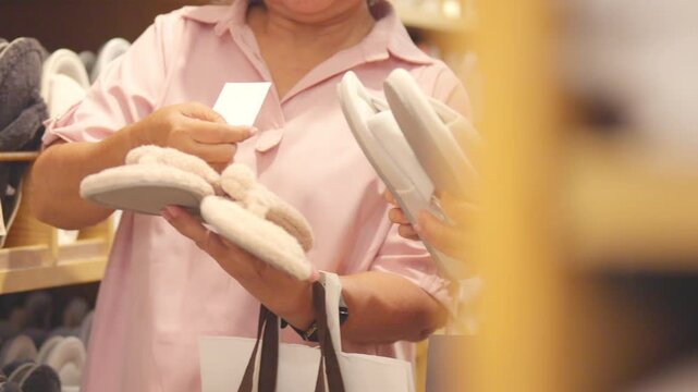 Happy Asian senior women friends shopping at department store in the city. Healthy elderly woman enjoy urban lifestyle choosing and buying gift at shopping mall. Active seniors people mental health.