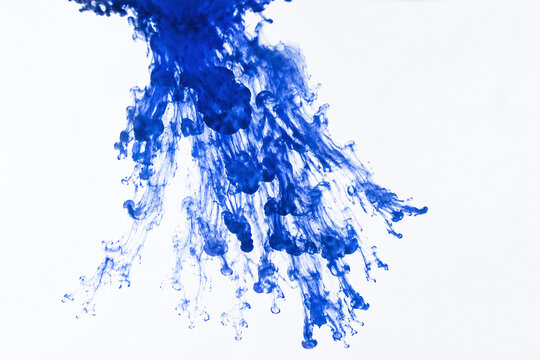 Deep blue ink plume dispersing through clear water