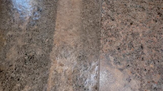 Granite countertop surface with water flowing steadily across it