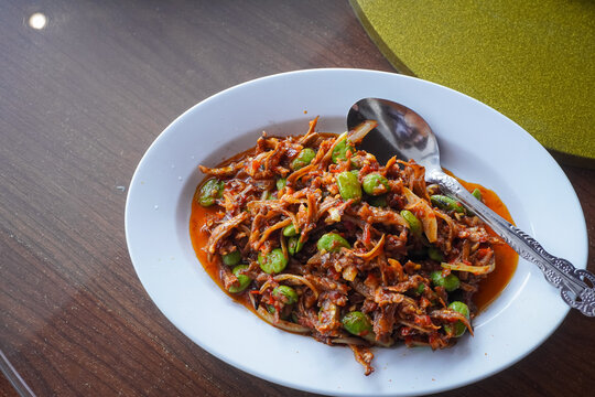  plate of shredded meat or fish dish, such as daging suwir or tongkol suwir with chili and sliced green onions