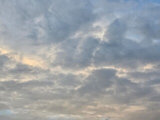 Obraz premium Soft Cloudscape at Dusk: Wispy, textured clouds drift across the twilight sky, painted with delicate hues of grey and pale yellow, creating a serene and ethereal atmosphere.