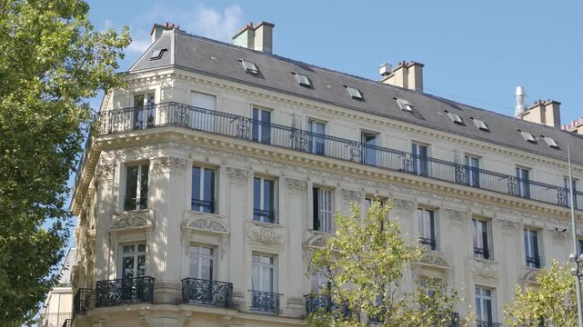 Corner Haussmann building showing balconies and windows on a sunny day