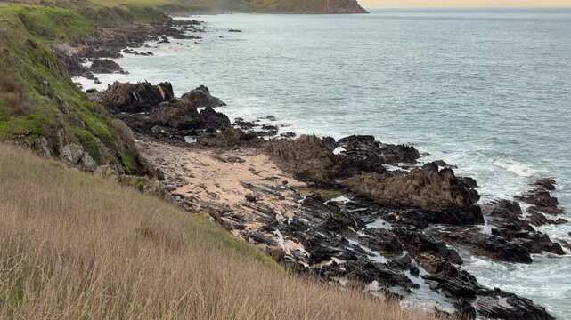 The Bluff rises out of the ocean at dusk on the Fleurieu Peninsula in South Australia in 60FPS 4K video footage