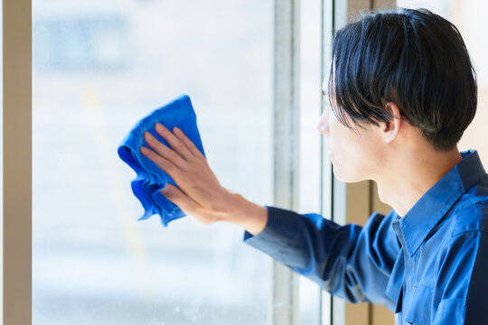 窓の拭き掃除をする家事代行の男性