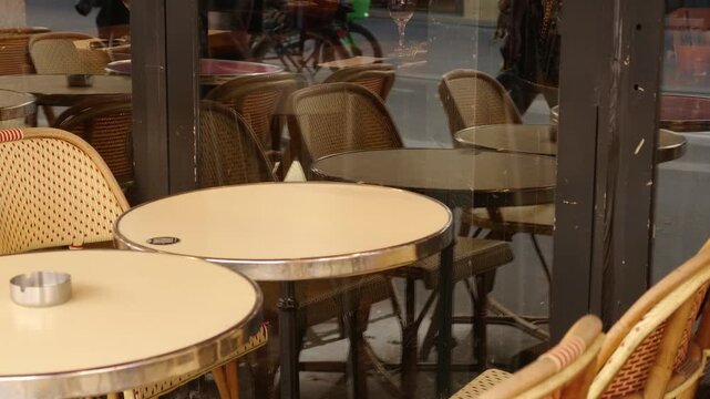 Parisian outdoor cafe tables and chairs with reflections of the city street