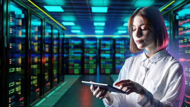 Data center. Server administration. IT specialist monitors server infrastructure with a digital tablet, managing network performance, cloud systems and data center operations.