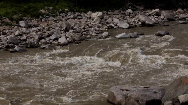 Close-up video captures rapid muddy water flowing through the Beas River following heavy monsoon rainfall in Mandi, Himachal Pradesh, India.