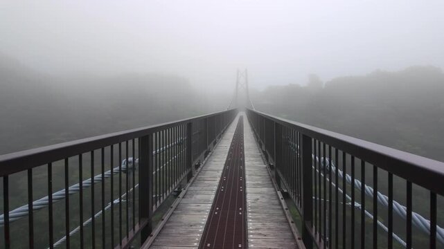 POV walking across the Tsutsuji Suspension Bridge into thick morning fog in Nasu, Japan
