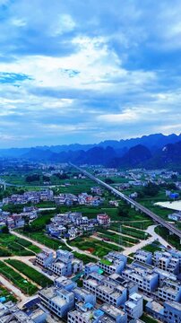 Vertical Video: High-speed train heading toward the morning sun over karst hills with mist still lingering in the valleys