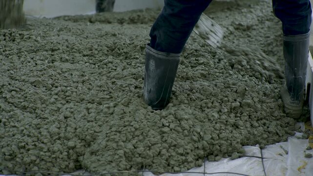 Construction Worker Spreading Wet Concrete