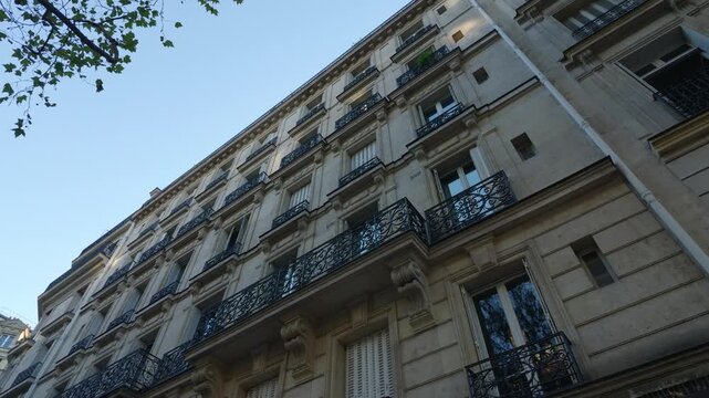 Paris Haussmann style apartment building facade featuring balconies and wrought iron railings