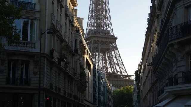 Eiffel Tower landmark seen behind classic Haussmann buildings along a street in Paris