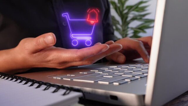 Close-up of a businesswoman working on her laptop while holding a virtual shopping cart icon with a notification bell.