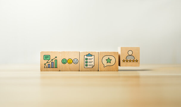 Customer satisfaction feedback concept with wooden blocks showing review rating, survey checklist, emotion icons, comment bubble, service quality and customer experience analytics