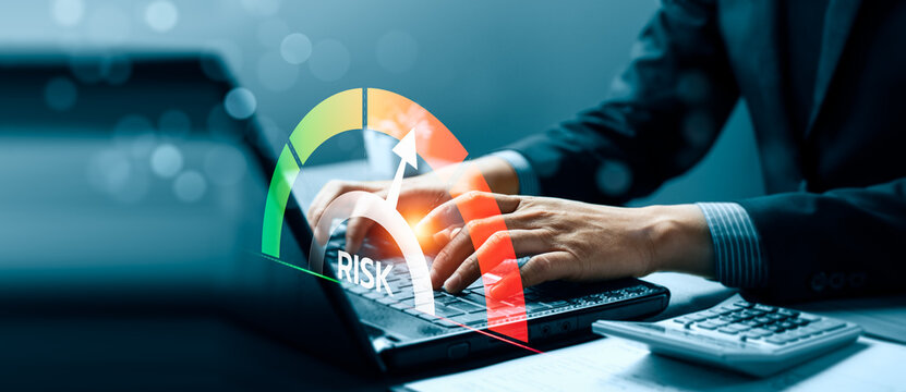 Business risk assessment concept with professional typing on laptop and virtual risk gauge interface showing warning level, financial analysis and corporate decision management