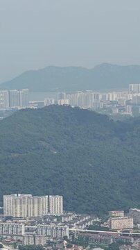 Aerial panning view of Penang coastal city, George Town, featuring Homo sapiens settlements near ocean and tropical foliage, Malaysia