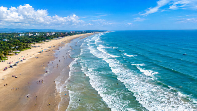 Tropical Beach and Blue Ocean Coastline with Golden Sand, Gentle Waves, Bright Sky and Clouds, Scenic Seaside Landscape for Summer Travel, Vacation and Paradise Holiday Concepts
