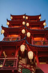 Obraz premium Illuminated Red Chinese Pagoda at Dusk with Lanterns