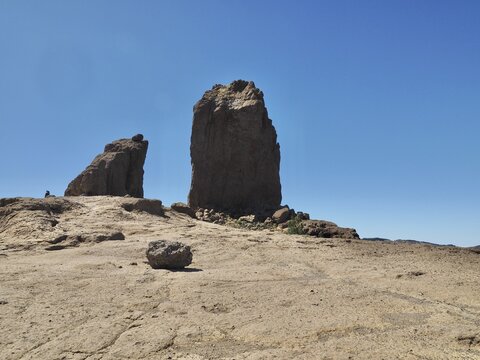 Individual high rocks, right Roque Nublo, left La Rana, in a barren landscape under blue sky, Roque Nublo, Gran Canaria, Spain