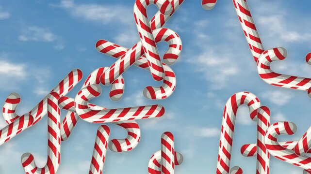 Red and White Striped Candy Canes Falling Against Blue Sky