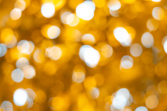 Gold nature blur abstract bokeh background. Abstract blooming yellow mustard stems amidst soft golden bokeh and brilliant sun rays for nature background layout.