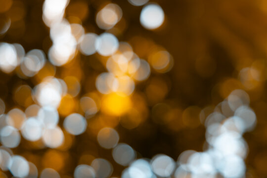 Gold nature blur abstract bokeh background. Abstract blooming yellow mustard stems amidst soft golden bokeh and brilliant sun rays for nature background layout.
