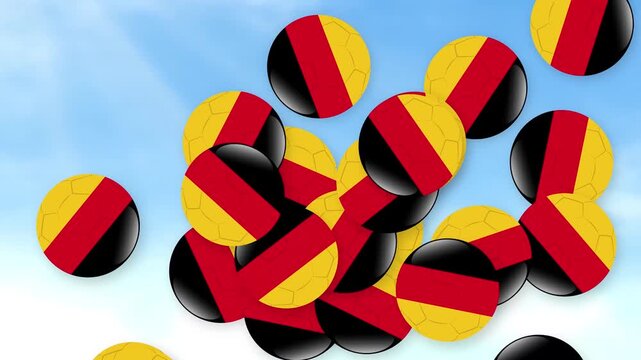 Falling Soccer Balls with German Flag Colors Against a Cloudy Blue Sky