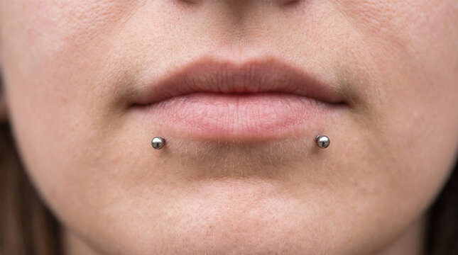Close Up of Woman Lower Lip with Symmetrical Silver Snake Bites Piercings
