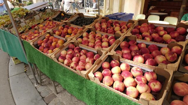 Ripe nectarines and peaches displayed in wooden crates at an outdoor fruit stand