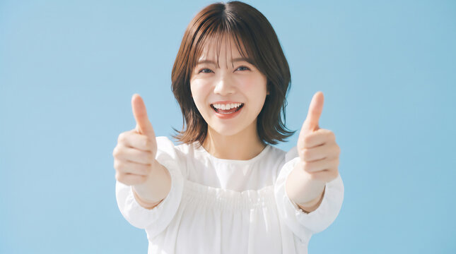 Happy young Japanese woman giving double thumbs up gesture toward camera