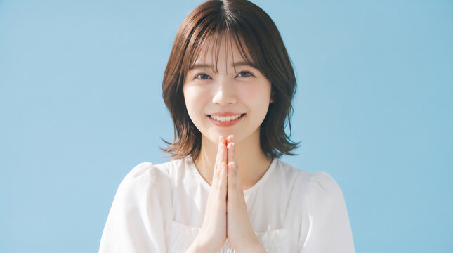 Young Japanese woman putting hands together in praying or asking gesture