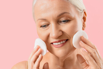 Healthy aging and skincare routine, mature woman cleaning face with cotton pads for facial hygiene...