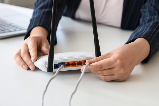 Internet connectivity and network setup, person connecting ethernet cable to wireless router for home office or business broadband infrastructure