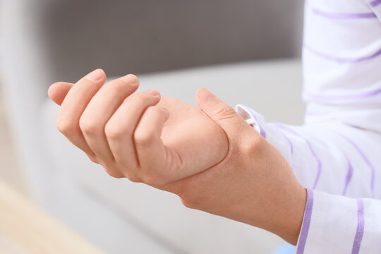 Wrist pain and joint inflammation, person holding painful hand with carpal tunnel syndrome or repetitive strain injury in a medical care