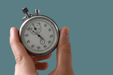 Time management and deadline pressure, hand holding a vintage stopwatch to measure performance and...