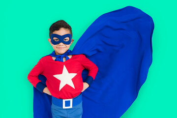 Child in superhero costume with red shirt and blue cape on teal background. © Rawpixel.com