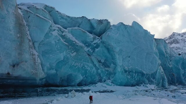 Three Trekkers Walking Along Massive Blue Ice Wall at Laiqu Glacier, Tibet