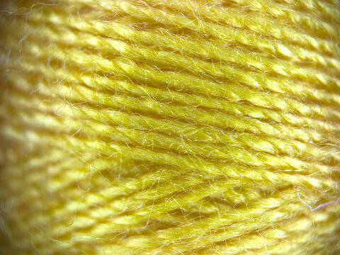 Yellow yarn thread texture close up macro concept for knitting, textile industry, handicraft hobby, wool material background, eco friendly fabric, needlework, and bright green wallpaper design. High q