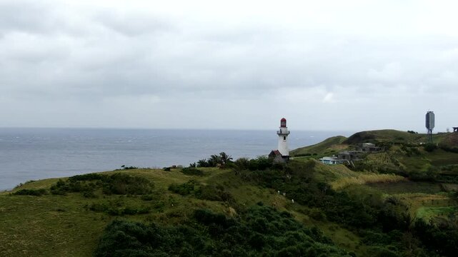 Aerial forward flight of Basco Lighthouse and historic Magnus wind turbine on Naidi Hills, Batanes